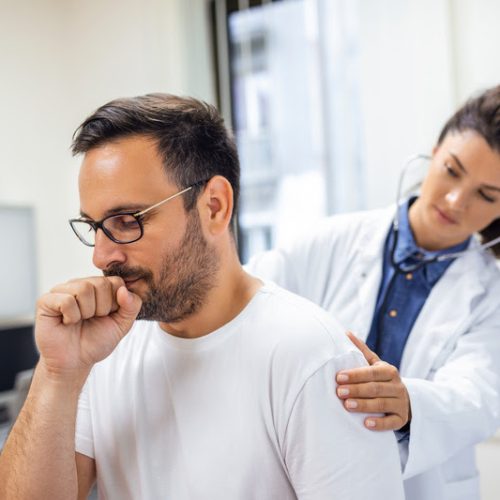 A female doctor at the clinic performs auscultation of the lungs of a patient with symptoms of coronavirus or pneumonia.
