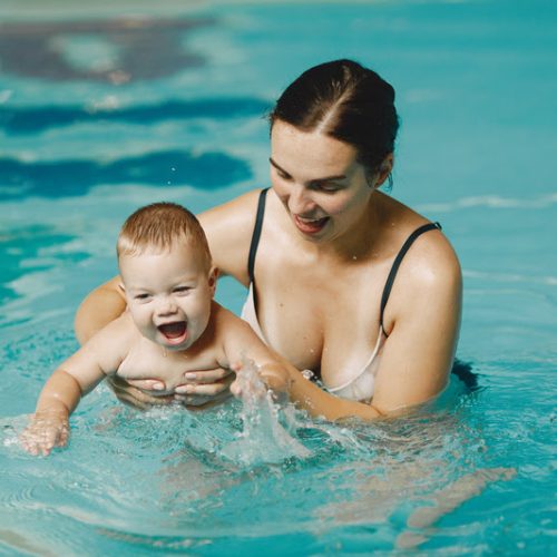 Little cute baby boy. Mother with son. Family playing in a water.